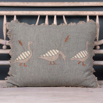 blue linen cushion with three appliquéd geese and embroidered grass detail