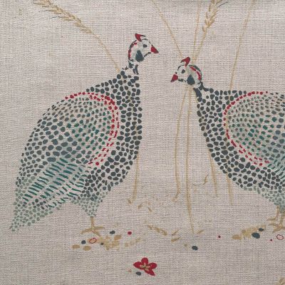 linen fabric printed with an intricate design of two guinea fowl in shades of blue red and gold