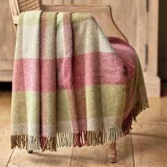 checked wool throw in shades of bright green and pink and finished with a fringe edge