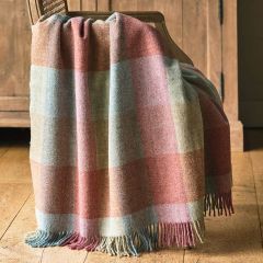 checked wool throw in shades of pale pink, blue and green draped over a wooden chair