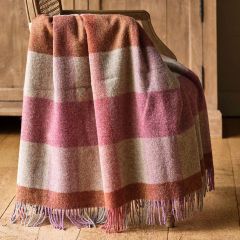 checked wool throw in shades of violet and burnt orange draped over a wooden chair